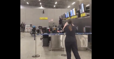 a woman standing in front of a counter with a few screens